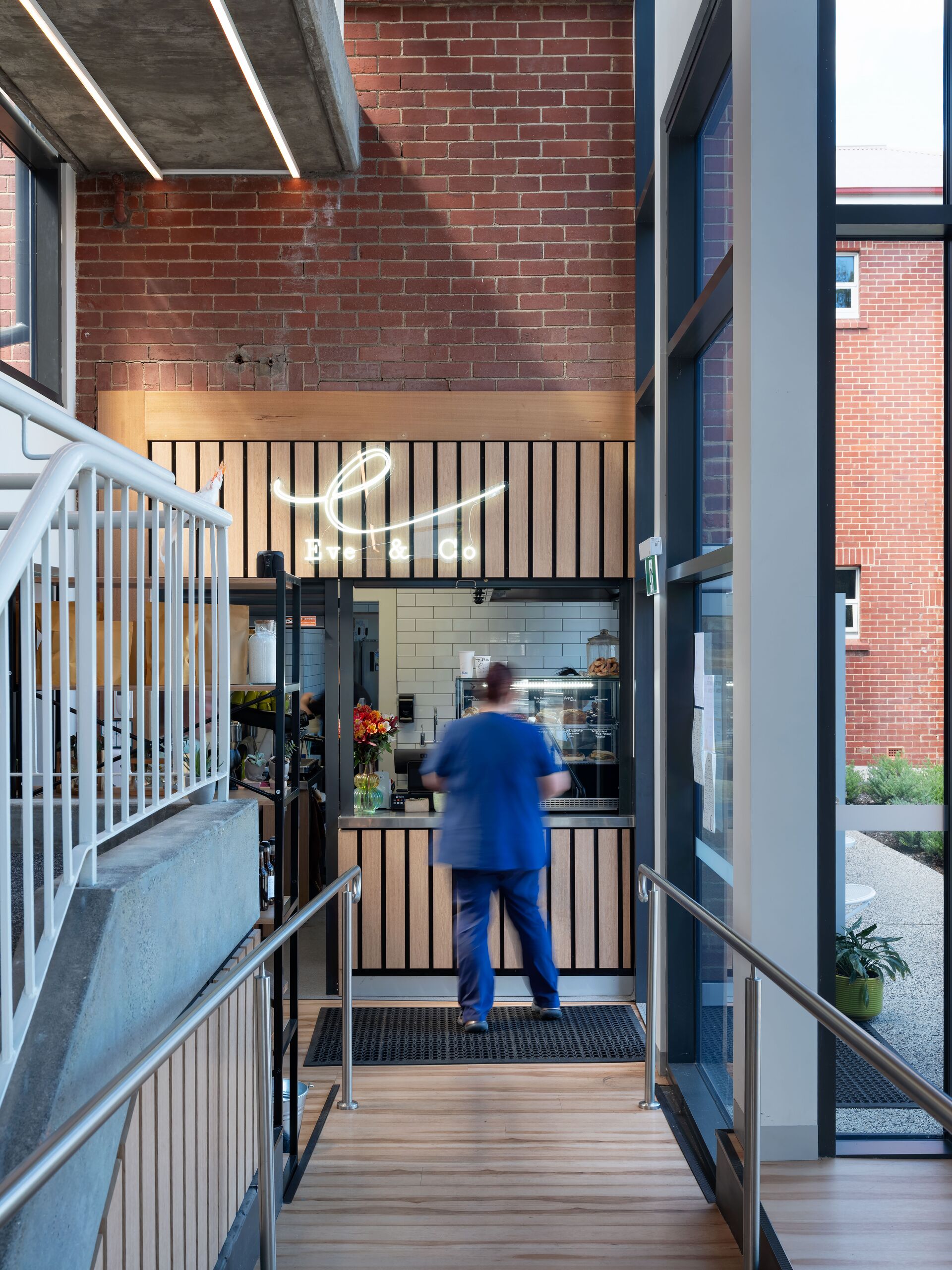 Café servery seen from the atrium, with original brick wall and timber batten screen