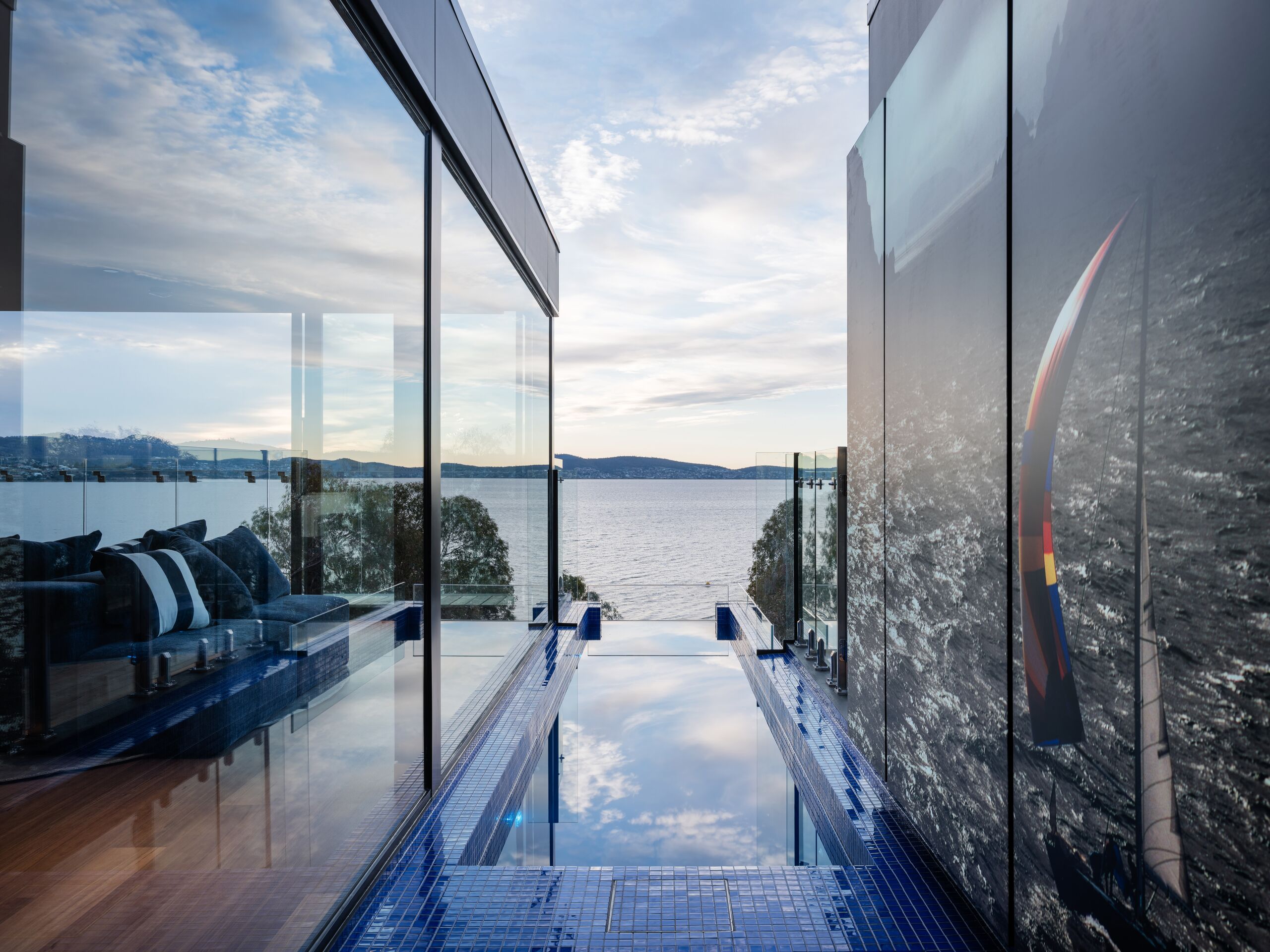 Glass-edged pool reflecting the sky beside the glazed living area